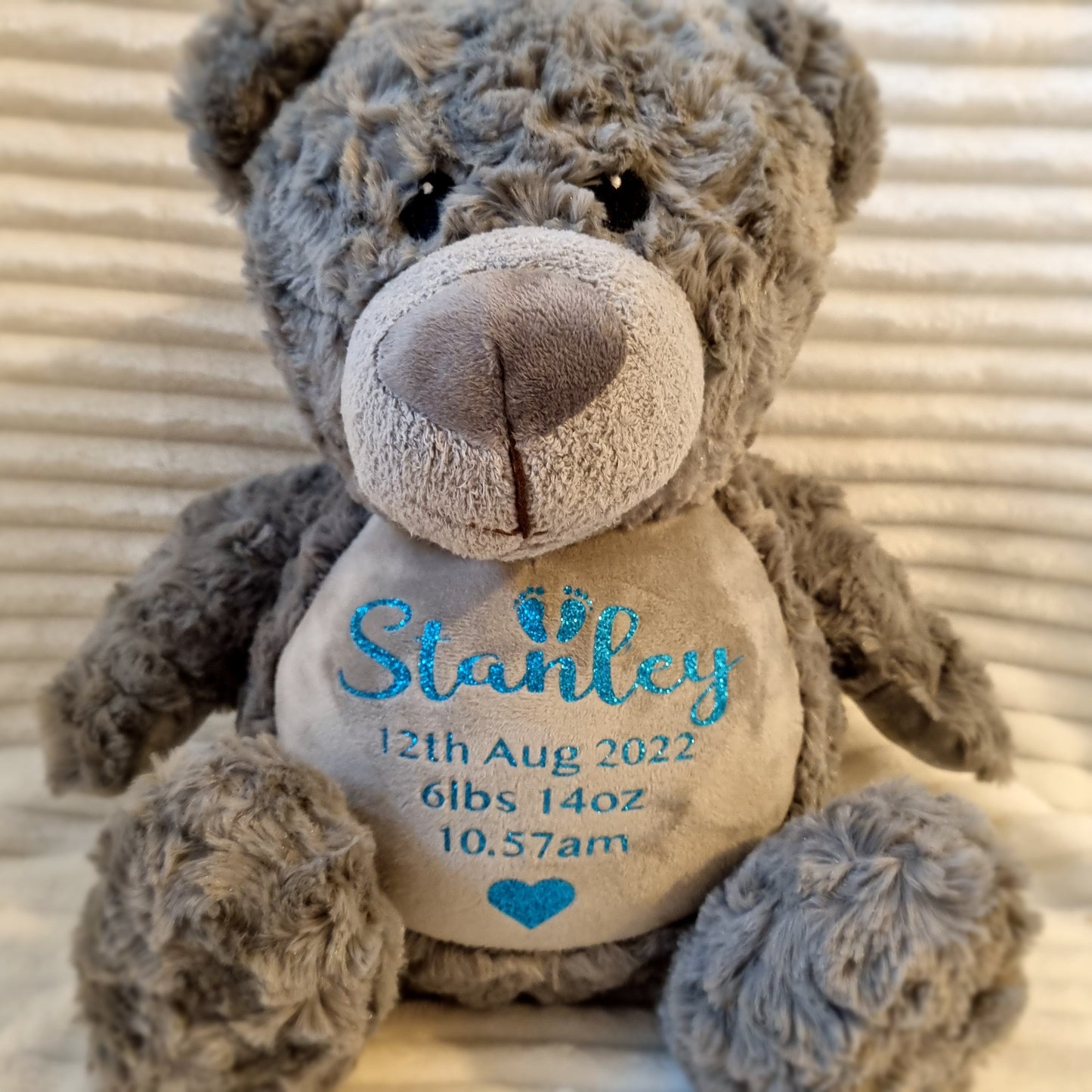 Gray embroidered teddy bear with birth weight details on belly