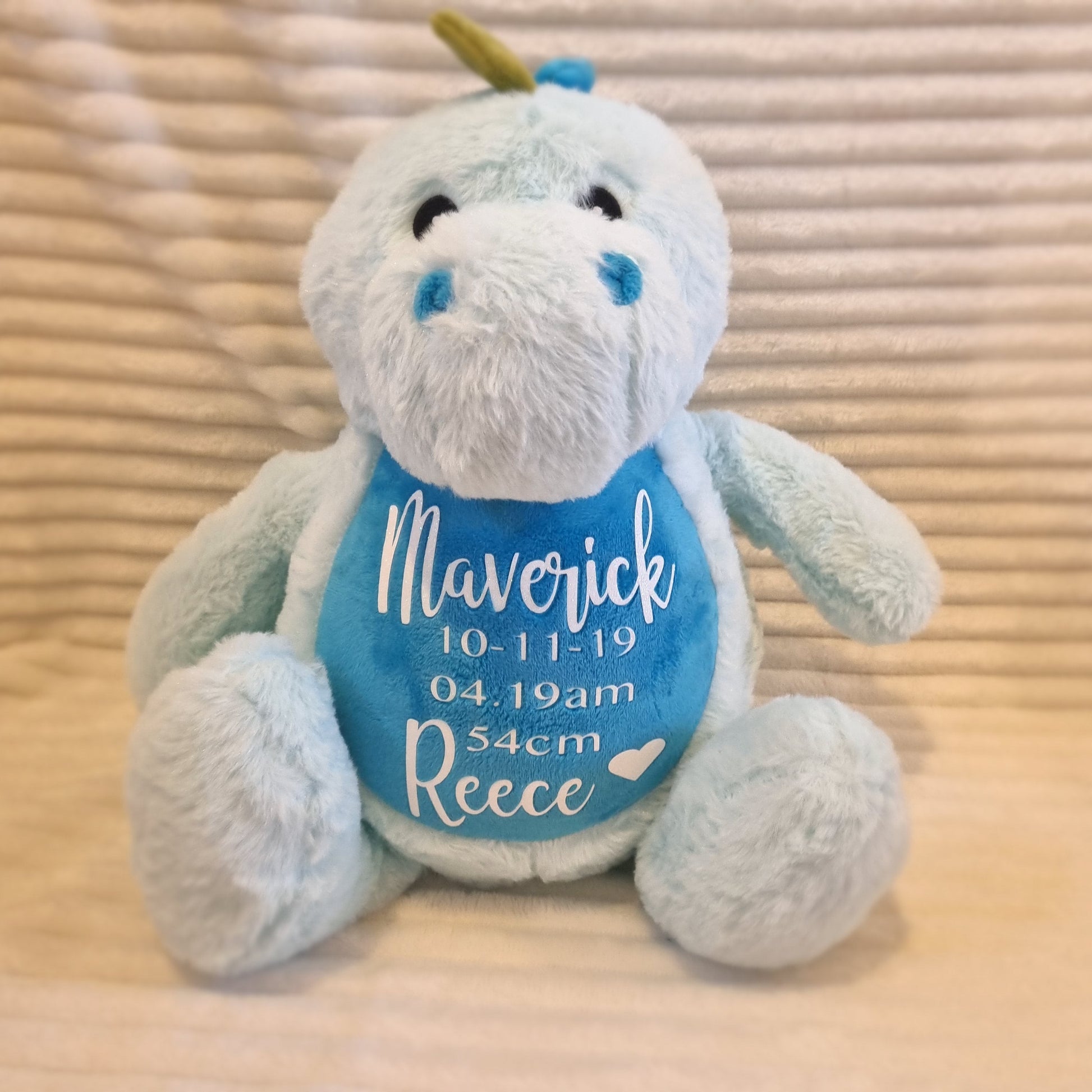 Light blue birth weight blue plush dinosaur toy with embroidered bib